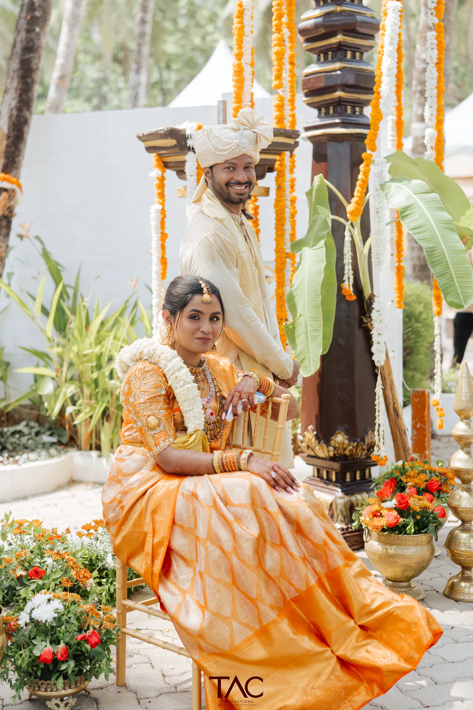 Couple portrait with brass lamp and marigolds, Adyar Gardens, Mangalore