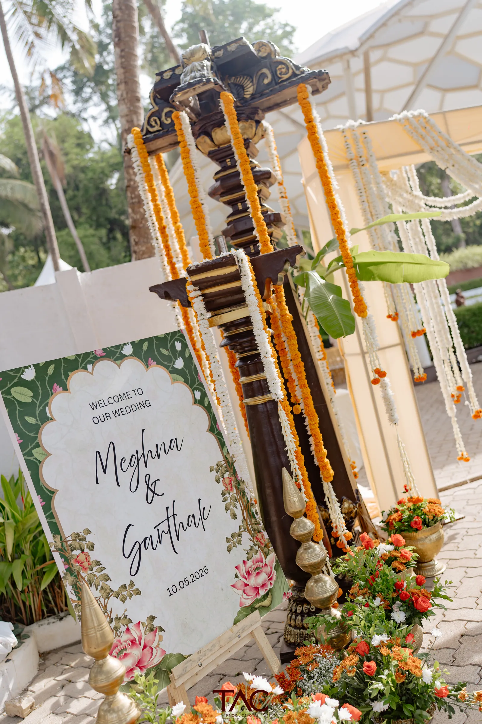 Welcome signage and brass lamp decor, Meghna and Sarthak's wedding at Adyar Gardens, Mangalore